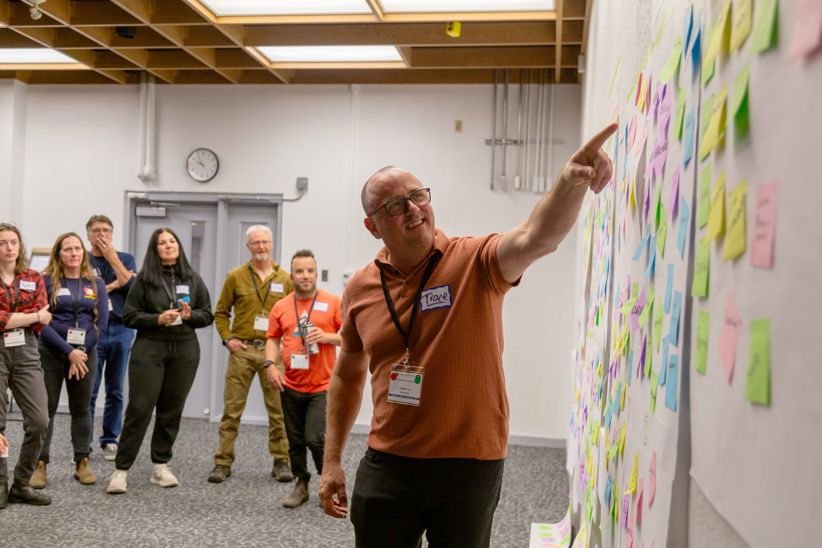 Trace Hobson facilitating a Psychological Health and Safety workshop with operational leaders, pointing to a wall of participant insights